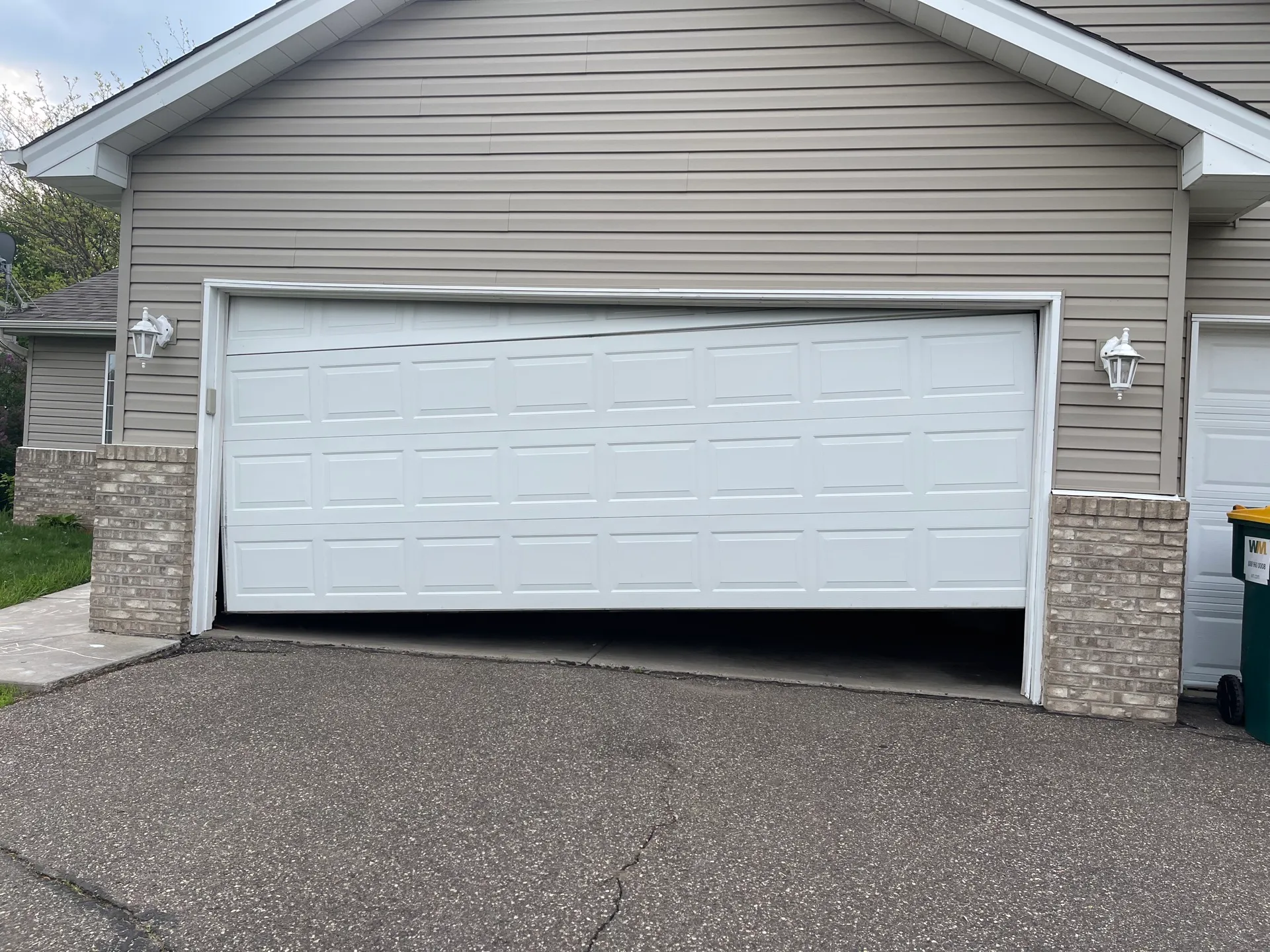 Classic white raised-panel double garage door on a tan craftsman home