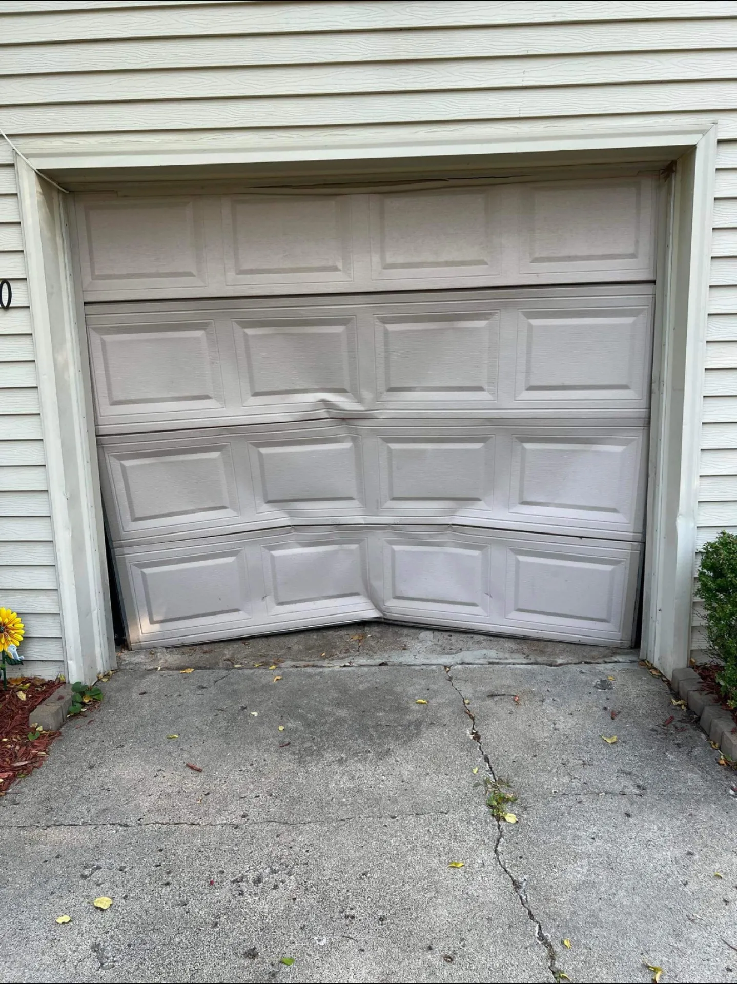 Dented and damaged residential garage door panel needing repair